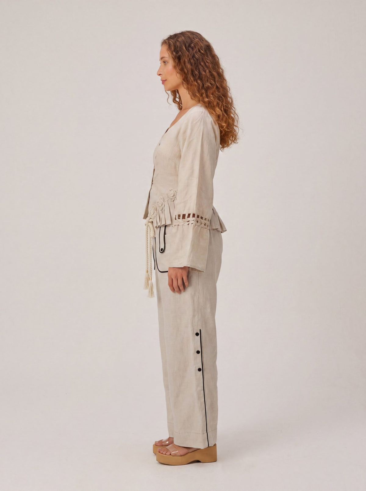 Rumi Top, handcrafted pure linen corset top with hand-braided sleeves, pleated ruffle hem and recycled floral appliques – close-up detail